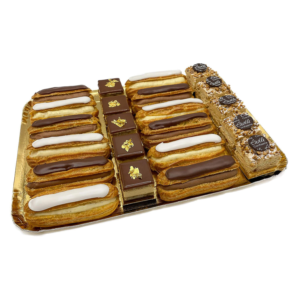 Kleine Eclairs mit Schokolade und Vanille, Opéra-Schnitte und Frankfurter Kranz auf goldener Platte.